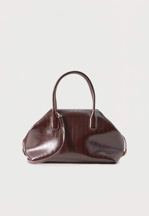 Donkerbruine glanzende leren handtas met twee handvatten en een afneembare schouderriem, geplaatst tegen een effen lichte achtergrond.