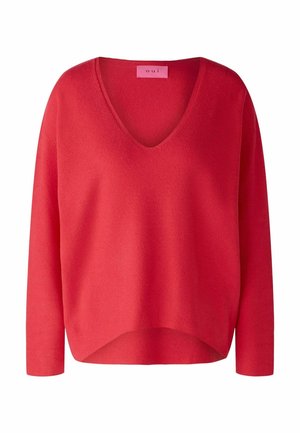 Czerwony sweter na długi rękaw z dekoltem w serek, wykonany z dzianiny, z lekko zaokrąglonym dołem i różową metką marki wewnątrz kołnierza.