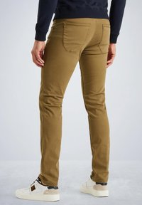 Pantalons slim fit de couleur kaki avec poches arrière, en tissu lisse. Présentent une légère élasticité et un design à taille basse.