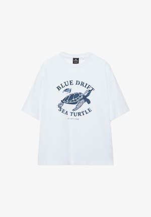 Weißes T-Shirt mit kurzen Ärmeln, vorne mittig mit einer blauen Meeresschildkröte und dem Text "BLUE DRIFT SEA TURTLE ATLANTIC ZONE" bedruckt.