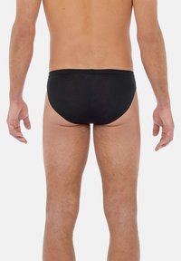 Zwarte zwemslips van gladde, rekbare stof, met een low-rise snit en minimale stiksels. Geen zichtbare logo's of patronen.