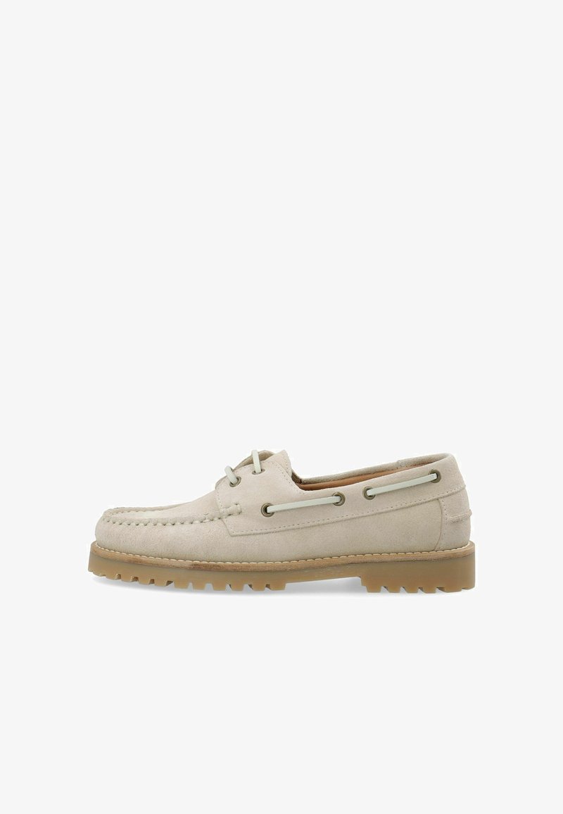 Bateaux en suedine beige avec un design mocassin, dotés de lacets ronds et d'œillets en métal. Semelle en caoutchouc légèrement relevée avec des rainures.