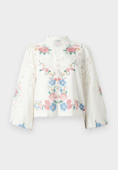 Λευκό μπλουζάκι με μακριά μανίκια, λεπτομέρειες από δαντέλα και πολύχρωμη κεντητή λουλουδένια διακόσμηση σε ροζ, μπλε και πράσινο, με ψηλό γιακά από δαντέλα και κουμπιά μπροστά.