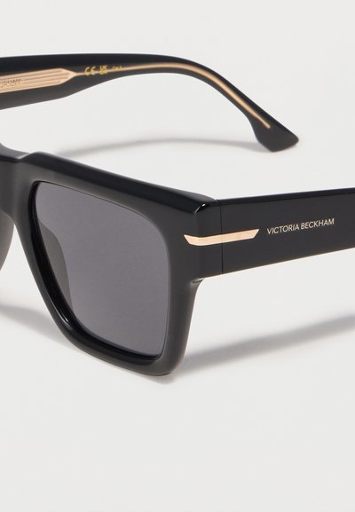 Μαύρα ορθογώνια γυαλιά ηλίου με σκοτεινούς φακούς και χρυσές λεπτομέρειες, με το λογότυπο «Victoria Beckham» στο μπράτσο του βραχίονα.