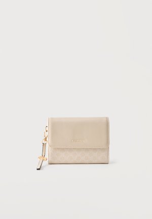 Beige kompakt pung med tekstureret nederste halvdel, glat klap, gyldent "ANNA FIELD" logo og en guldfarvet nøglering med en sort strop monteret.