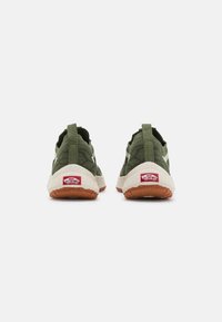 Groene textielsneakers met witte accenten, rubberen zool en een kenmerkend rood Vans-logo op de hiel. Voorzien van een achterste lus voor gemakkelijk aan- en uittrekken.