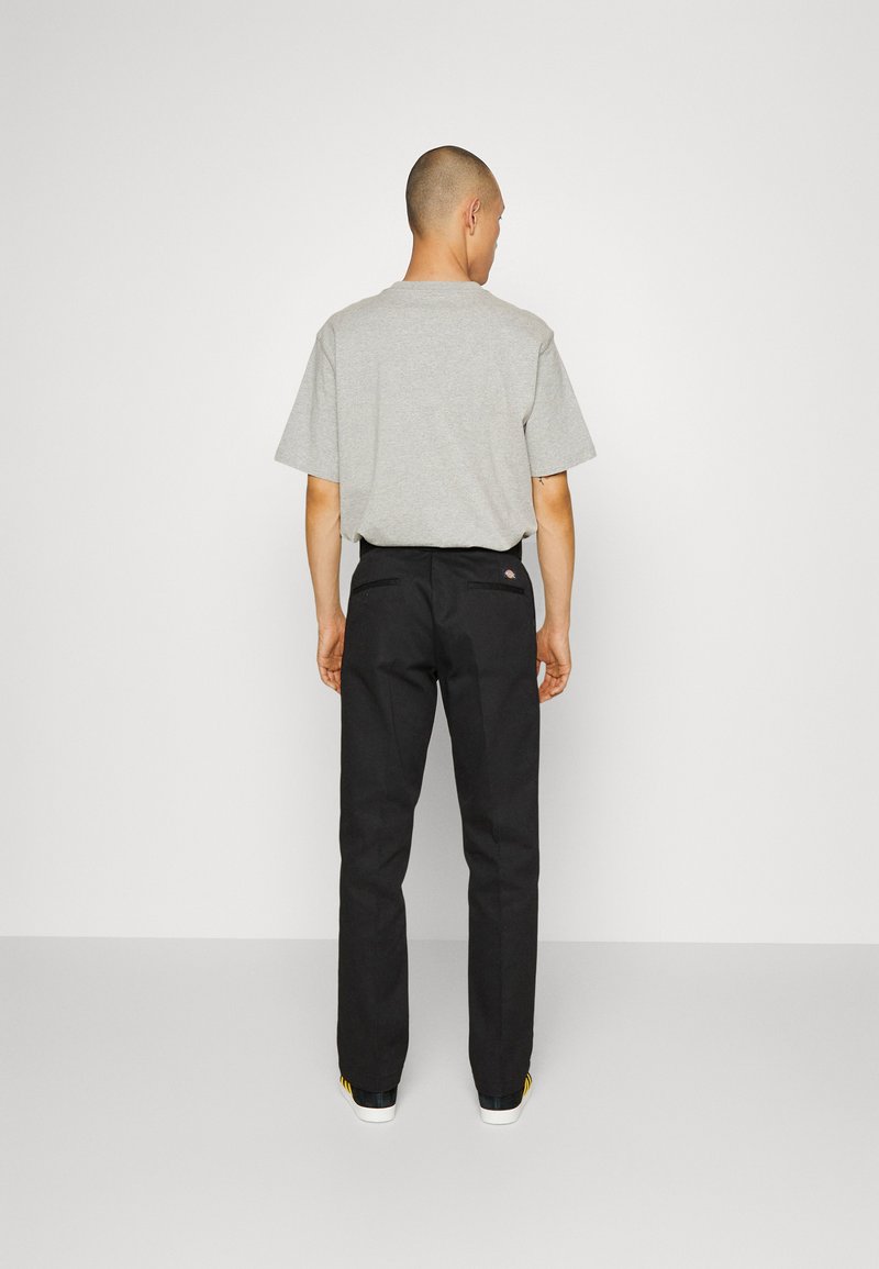 Men's casual outfit featuring a gray short-sleeve t-shirt and black straight-leg pants. The pants have two rear pockets and subtle branding.
