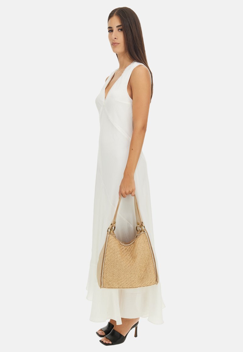 Una borsa in paglia intrecciata con una forma curvata e dettagli beige. La borsa presenta due manici e una superficie liscia e testurizzata.