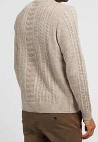 Beigen värinen palmikkoneulepusero, jossa on teksturoitu kuvio, pyöreä pääntie ja resorit hihansuissa. Saumojen kohdalla näkyvät tikit.