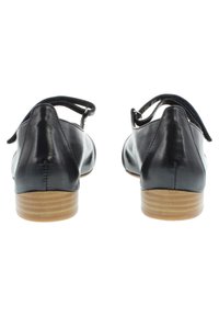 Scarpe in pelle nera con tacco in legno basso, dotate di una cinghia posteriore e una finitura liscia. Design minimalista senza decorazioni.