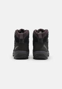 Svarta vandringsskor med en mesh-överdel, förstärkt häl och strukturerade detaljer. Har en robust gummisula för grepp och hållbarhet.