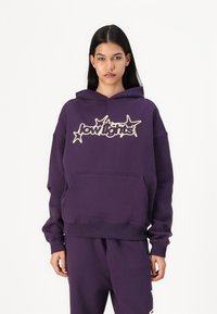 Hanorac violet cu glugă, dotat cu o buzunar frontal și un logo grafic de culoare galben deschis. Material moale și croială lejeră.