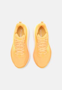 Des chaussures de course orange vif avec un dessus en maille, un col rembourré et une semelle intermédiaire blanche. Les lacets sont également orange avec une finition texturée.