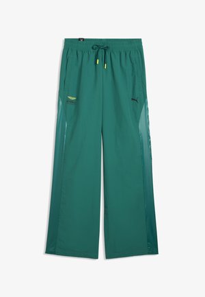 Pantalon de survêtement large couleur sarcelle avec taille à cordon, poches latérales, logo Puma sur la droite et logo Aramco sur la cuisse gauche.