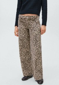 Pantaloni a gamba larga in stampa leopardata realizzati in morbido tessuto; tonalità neutre con macchie scure; presentano tasche laterali e una vita con bottone.