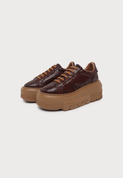 Ζευγάρι καφέ sneakers με υφή δέρματος φιδιού, χοντρές καφέ σόλες και αντίστοιχα καφέ κορδόνια σε λευκό φόντο.
