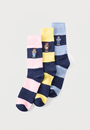 Three pairs of striped socks in pink, yellow, and blue with navy stripes, each featuring a small embroidered bear wearing casual outfits.