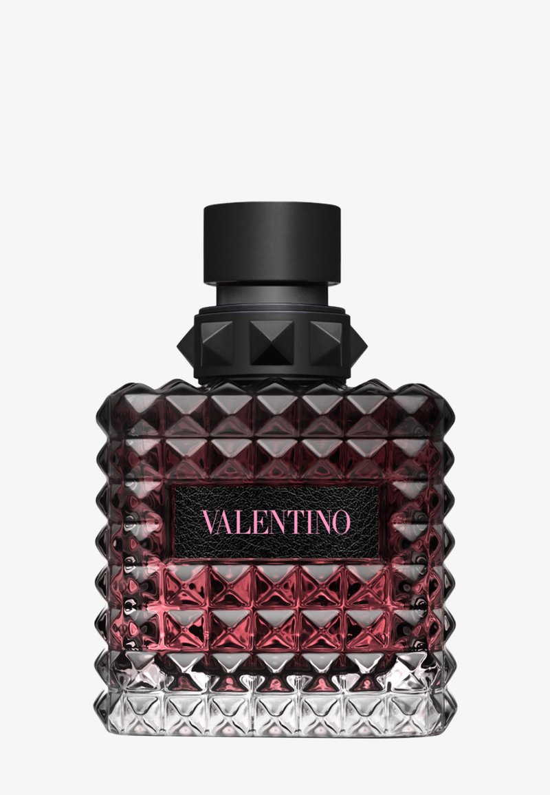 Firkantet, teksturert glass parfymeflaske med svart kork og naglet krage, inneholder mørk rosa væske, merket Valentino i rosa tekst.