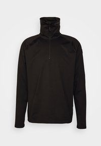 Suéter negro con cuello alto y media cremallera. Presenta mangas largas, costuras planas y un tejido suave y elástico. Ideal para llevar en capas.