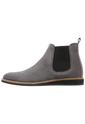 Bottes Chelsea en daim gris avec panneaux latéraux élastiques et bout rond. Dotées d'une semelle en caoutchouc noir et d'une surpiqûre beige sur la trépointe.