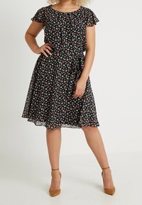 Czarna sukienka w kwiaty z krótkimi rękawami, wcięciem w talii i rozkloszowanym spodem. Posiada małe, wielokolorowe kwiatki oraz lekką, zwiewną tkaninę.