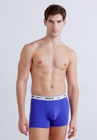 Lila Nike Boxer Shorts mit einem weißen elastischen Bund mit Logo. Glattes Material, taillierte Passform und Oberschenkel-langer Schnitt.