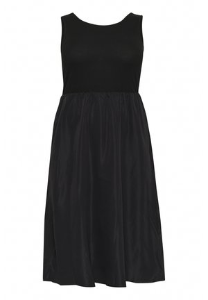 Črna brezrokavna obleka z oprijetim rebrastim zgornjim delom in ohlapno, naborkano krilo. Narejena iz gladkega materiala z mehakim sijajem.