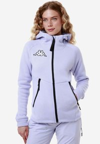 Felpa con cappuccio di pile di colore lilla chiaro, con cerniera nera, tasche frontali e logo ricamato. Presenta un collo alto e cappuccio regolabile.