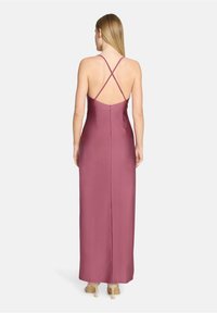 Robe longue et ajustée de couleur mauve profond, avec un design de bretelles croisées dans le dos, une texture satinée lisse et une fermeture éclair dissimulée au dos.