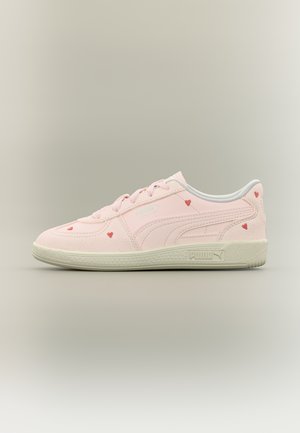 Baskets Puma rose clair à lacets, accents en forme de cœur rouge et semelle blanc cassé, vues de côté extérieur sur fond uni.