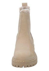 Botas de tobillo beige con un upper de cuero suave, ribete de piel sintética en la parte superior y una suela de goma gruesa y estriada. Sin cordones; diseño de tipo slip-on.