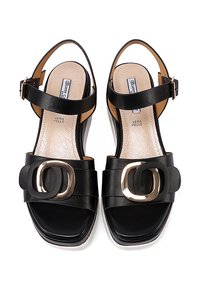 Sandali in pelle nera con una larga fascia anteriore e fibbia metallica circolare. Presentano una cinghia alla caviglia regolabile e una soletta imbottita.
