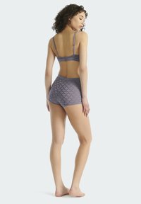 Fialová podprsenka a odpovídající krátké kalhoty s vysokým pasem s květinovým vzorem. Má nastavitelné ramínka a hladkou, jemnou texturu.