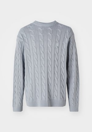 Pullover en tricot bleu clair avec un motif en torsades, manches longues et col rond. Les poignets et l'ourlet côtelés ajoutent de la texture et de la structure.