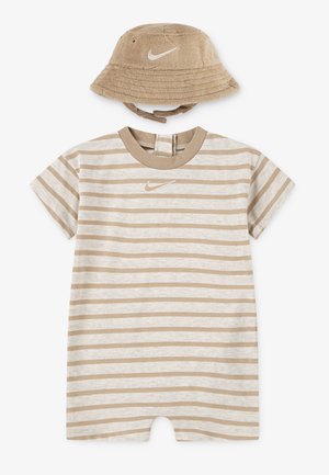 Beige og hvitstripet kortermet romper med Nike-logo og matchende beige Nike bøttehatt laget av mykt stoff.
