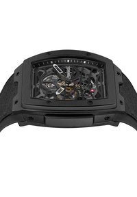 Czarny skeletonowy zegarek z prostokątną kopertą, przezroczystą tarczą ukazującą skomplikowane mechanizmy, teksturowanym czarnym paskiem i subtelnymi czerwonymi akcentami.