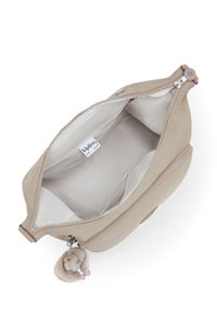 Beige fabric bag with a smooth texture, zip closure, and a plush charm. Interior features a light lining and a branded label.