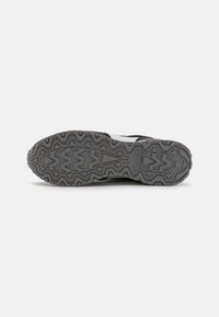 Suela de zapato atlético negro con un diseño texturizado rugoso, patrón en zigzag y material de goma duradero centrado en el agarre.