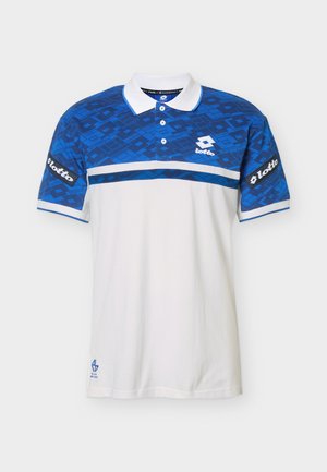 Rövid ujjú póló fehér testtel, kék geometriai mintás felső mellkas- és ujjrészekkel, fehér gallérral, valamint Lotto logókkal a mellkason és az ujjakon.