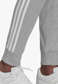 adidas Sportswear Spodnji deli trenirk - medium grey heather/white