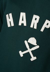 Sudadera verde oscuro con texto bordado en blanco "HARP" y un gráfico de bates de béisbol cruzados y una gorra. Textura suave.