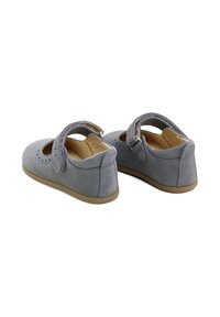 Zapatos Mary Jane de ante gris con detalles en corte y correa ajustable. Suela de goma marrón claro, puntera redonda y forro interior suave.