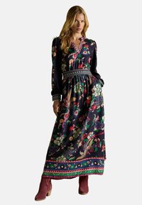 Pikk lilleline maksimekko tumesinisel taustal heledate ja erksate mustritega. Omab sügavat V-kaela, pikki varrukaid ning rõhutatult vööd.