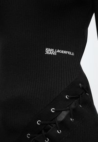 Μαύρο ριμπ ύφασμα με λευκή κεντητική "KARL LAGERFELD JEANS" και μαύρη δαντέλα με μεταλλικά οπές στο πλάι.