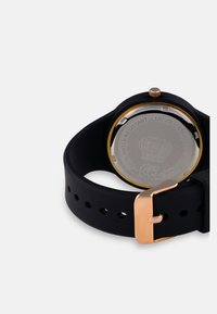Orologio da polso in silicone nero con un'accensione dorata sulla cassa e sulla fibbia, dotato di un retro in acciaio inossidabile, design resistente all'acqua e forma circolare.