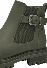 Olivově zelený kotníkový boty vyrobené z hladké kůže a texturované látky, s akcentem stříbrné přezky a drsnou, silnou podrážkou.