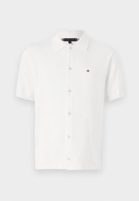 Biała koszulka polo z krótkim rękawem wykonana z bawełny, z kołnierzykiem na spiczasto, guziczkami z przodu oraz małym logo na lewej piersi.