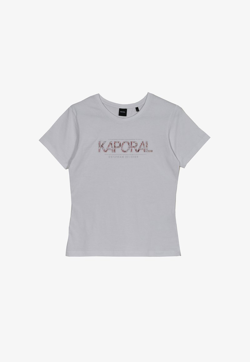 T-shirt en coton blanc à manches courtes et à col rond. Présente un texte graphique rouge "KAPORAL" et "DREAM BELIEVER" sur le devant.