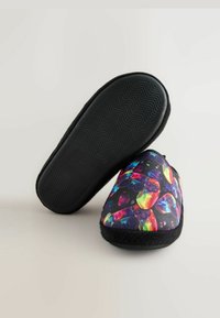 Bunte Hausschuhe mit einem lebhaften Muster aus Spielcontrollern und Edelsteinen, aus weichem Stoff und mit einer schwarzen Gummisohle.