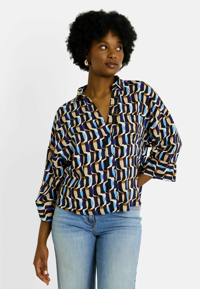 Chemise à motifs à manches courtes, présentant un mélange de courbes bleues, brunes et beige. Fabriquée en tissu lisse avec des détails de boutons.